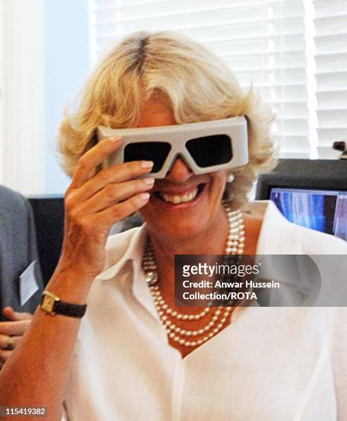 Duchess of Cornwall laughs as she wears 3D glasses to observe the changing forms of glaciers on a computer during a visit to the University of Wales,...