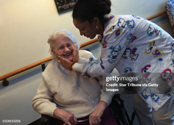 Walker Methodist resident Minnie Meyer, left, gets a loving touch from Nursing Assistant Devika Swanston, right, after Swanston finished brushing...