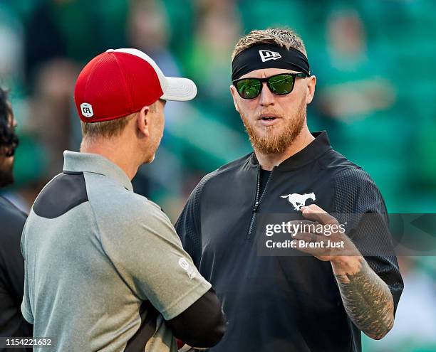 Injured Calgary Stampeder quarterback Bo Levi Mitchell talks with head coach Dave Dickenson on the field before the game between the Calgary...