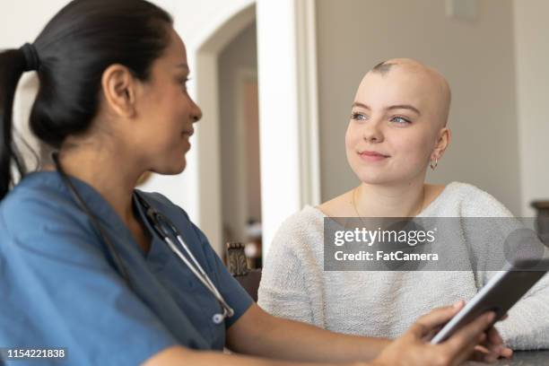 volwassen vrouw met verpleegkundige tijdens de thuiszorg bezoek - alopecia stockfoto's en -beelden