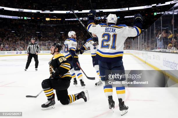 Tyler Bozak of the St. Louis Blues celebrates a goal by teammate David Perron after tripping up Noel Acciari of the Boston Bruins during the third...