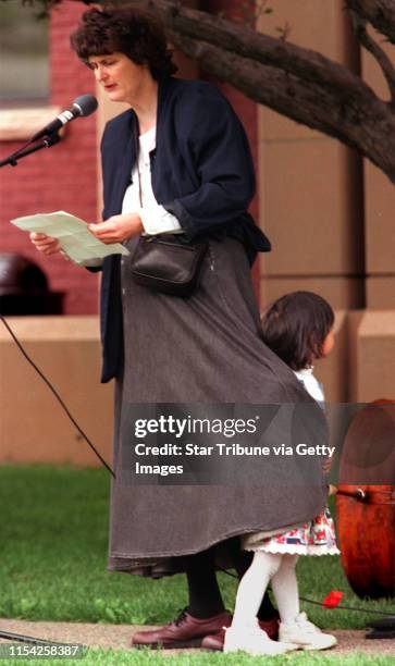 Poets reading at Kellog Park in St. Paul -- Mary Cummings of St. Paul reads her poetry while daughter Ada Breitenbucher, age 4, wraps up in mom's...