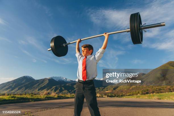 young boy zakenman tillen gewichten - flexibel stockfoto's en -beelden