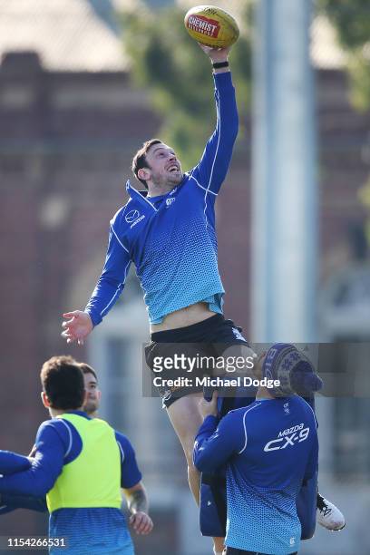 Todd Goldstein of the Kangaroos taps the ball down during a North Melbourne Kangaroos AFL training session at Arden Street Ground on June 07, 2019 in...