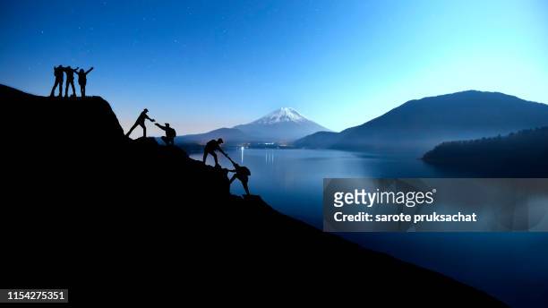 silhouette climbing group friends walking to hike up mountain .teamwork , helps ,success, winner and leadership concept . - muster stock pictures, royalty-free photos & images