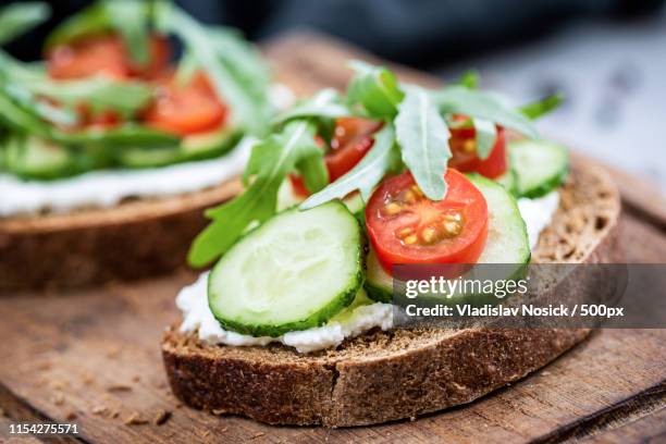 healthy food rye bread with cream cheese, cucumber, tomato - rye grain stock-fotos und bilder