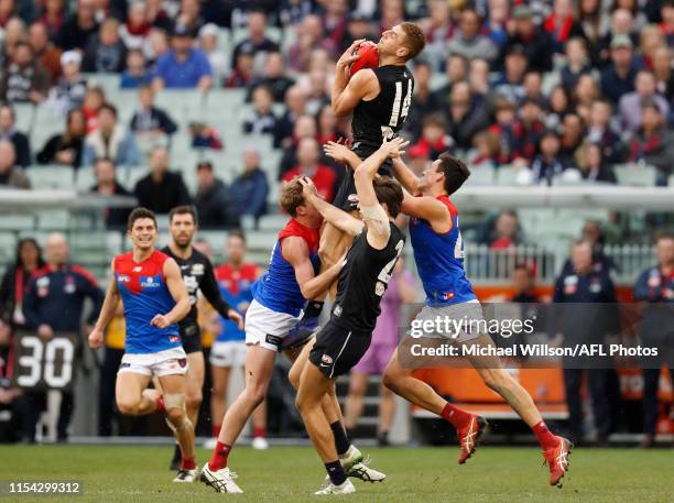 Liam Jones of the Blues takes a high mark over Mitch Hannan of the Demons during the 2019 AFL round 16 match between the Carlton Blues and the...