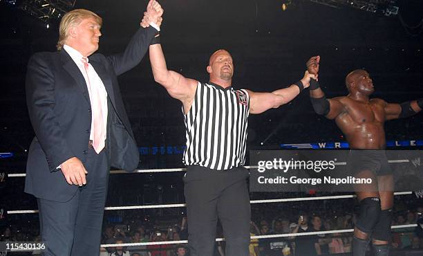 Special referee Steve Austin holds up the arms of Donald Trump and Bobby Lashley after their team won the "Battle of the Billionaires" match at...