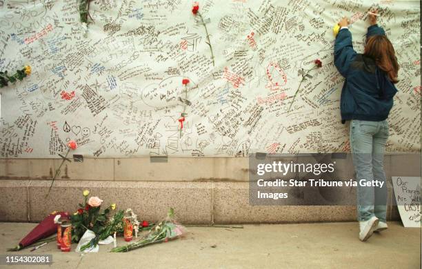 At the Denver Civic Center Amphitheater, at a candlelight vigil for victims of the Columbine HS shootings, Tamara Tatar writes her sentiments on a...