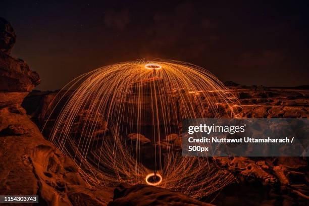 burning steel wool on the rock near the river - burning steel wool firework stock-fotos und bilder