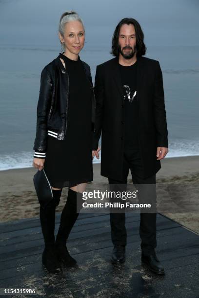 Alexandra Grant and Keanu Reeves attend the Saint Laurent Mens Spring Summer 20 Show on June 06, 2019 in Malibu, California.