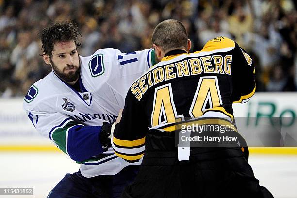 Ryan Kesler of the Vancouver Canucks fights with Dennis Seidenberg of the Boston Bruins during Game Three of the 2011 NHL Stanley Cup Final at TD...