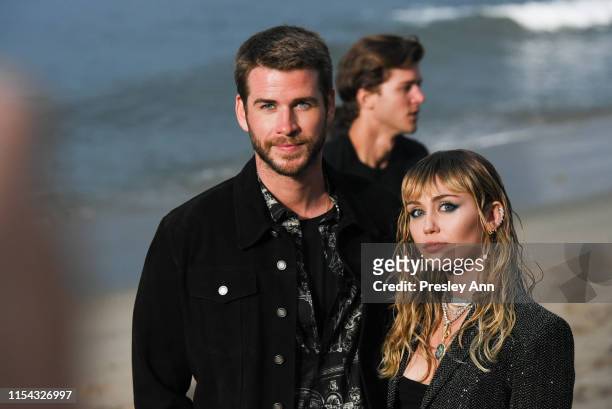 Liam Hemsworth and Miley Cyrus at Saint Laurent mens spring summer 20 show on June 06, 2019 in Malibu, California.