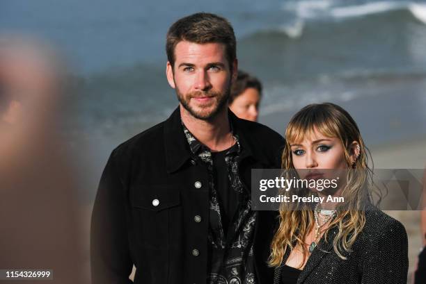 Liam Hemsworth and Miley Cyrus at Saint Laurent mens spring summer 20 show on June 06, 2019 in Malibu, California.