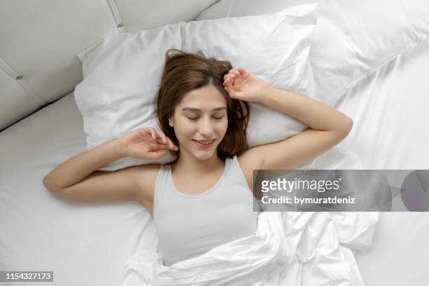 junge frau aufwachen am morgen - woman pillow over head stock-fotos und bilder