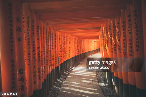 torii gates tunnel at fushimi inari shrine in kyoto, japan - religious symbol stock pictures, royalty-free photos & images