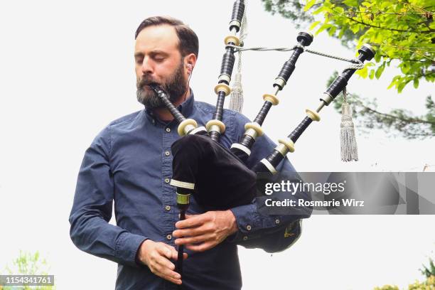 adult man playing scottish bagpipe - piper stock pictures, royalty-free photos & images