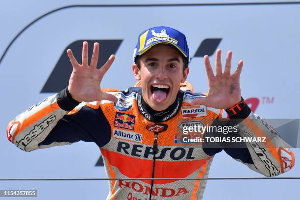 Repsol Honda Team's Spanish rider Marc Marquez shows the number 10 with his hands as he celebrates on the podium after winning the Moto GP Grand Prix...