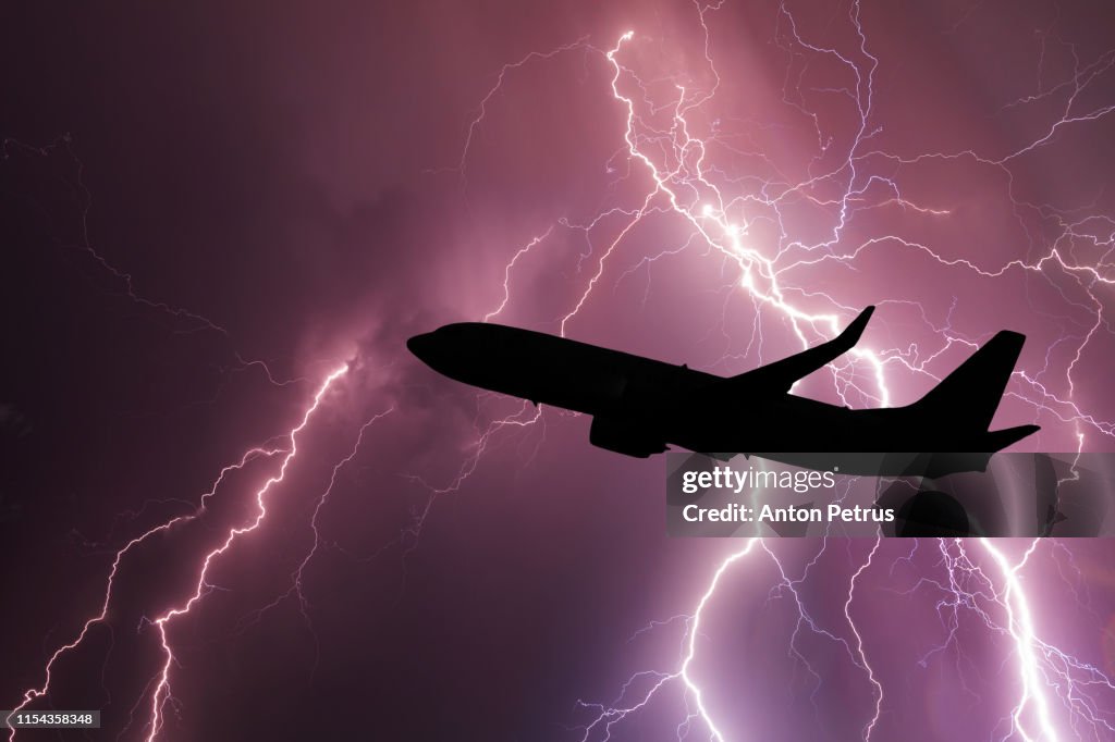 Airplane silhouette on the background of a stormy sky with lightning