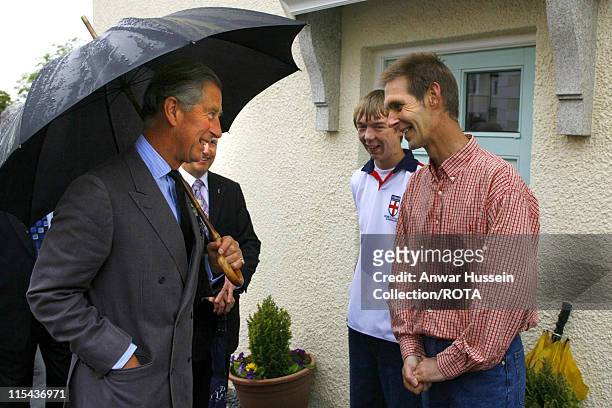 Prince Charles, the Prince of Wales,meets Neil Turner andson James during a visit to a housing development in Truro which has been built on land...