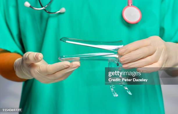 gynecologist holding vaginal speculum - gynecologist bildbanksfoton och bilder