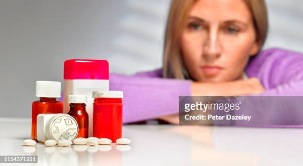 woman looking at pills - prozac stockfoto's en -beelden