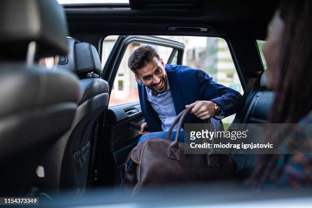 un hombre guapo entrando en auto compartiendo coche - entrando fotografías e imágenes de stock