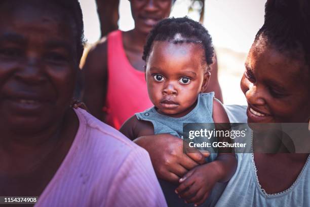 african toddler with his family in the village - zambia woman stock pictures, royalty-free photos & images