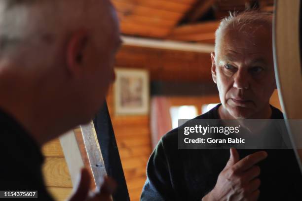 the elderly man is looking in the mirror - senior getting dressed stock pictures, royalty-free photos & images