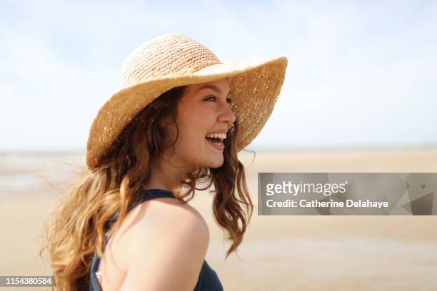 portrait of a young woman on the beach - hat stock pictures, royalty-free photos & images