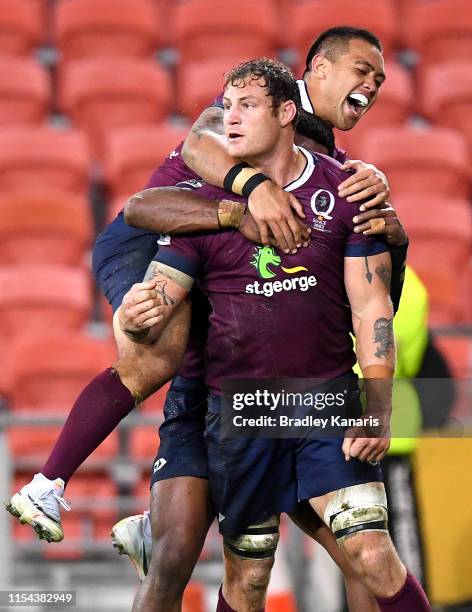 Scott Higginbotham of the Reds is congratulated by team mate Duncan Paia'aua after scoring a try during the round 17 Super Rugby match between the...