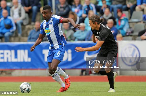 Salomon Kalou of Berlin challenges for the ball with Leon Buerger of Braunschweig during the pre-season friendly match between Hertha BSC and...