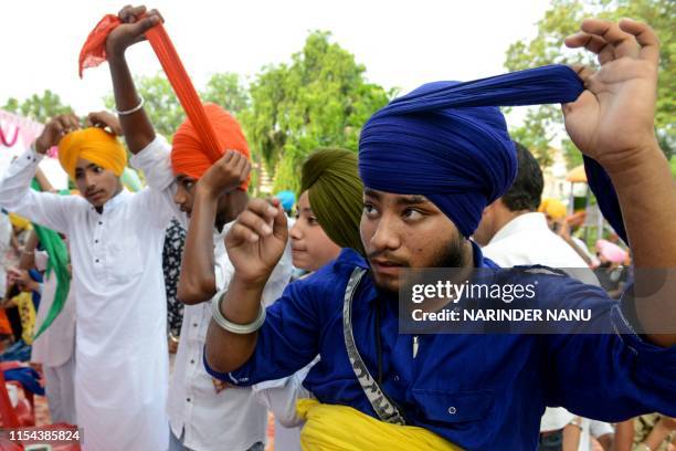 Indian Sikh youth participate in a turban-tying competition organised by the Shri Guru Ramdas Welfare Society in Amritsar on July 7, 2019. The...