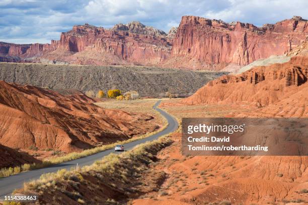 car heading north along the scenic drive towards the waterpocket fold, fruita, capitol reef national park, utah, united states of america, north america - capitol reef national park fotografías e imágenes de stock