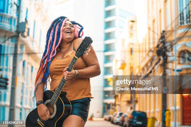 mulher do punk que joga a guitarra acústica - artista - fotografias e filmes do acervo