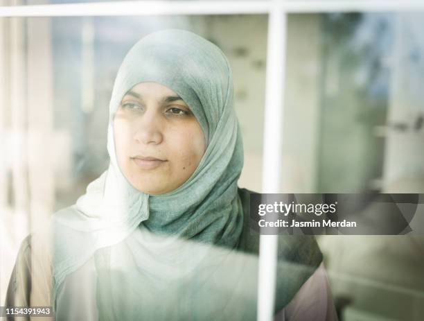 immigrant muslim woman contemplating - house of exile stock-fotos und bilder