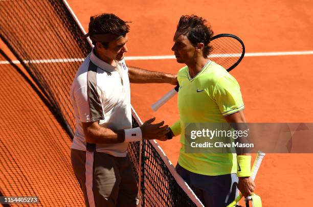 Rafael Nadal of Spain and Roger Federer of Switzerland embrace at the net after their mens singles semi-final match during Day thirteen of the 2019...