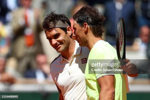 Rafael Nadal of Spain and Roger Federer of Switzerland embrace at the net after their mens singles semi-final match during Day thirteen of the 2019...