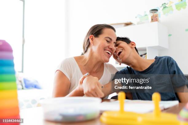 mother playing with son with cerebral palsy - cerebral palsy stock pictures, royalty-free photos & images