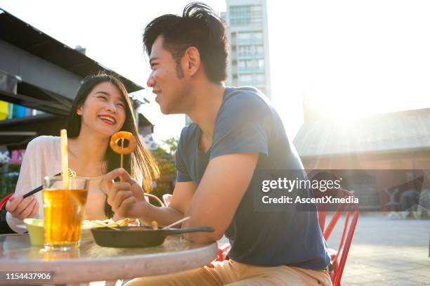 在人行道上的咖啡廳享用小吃和飲料的情侶 - onion ring 個照片及圖片檔
