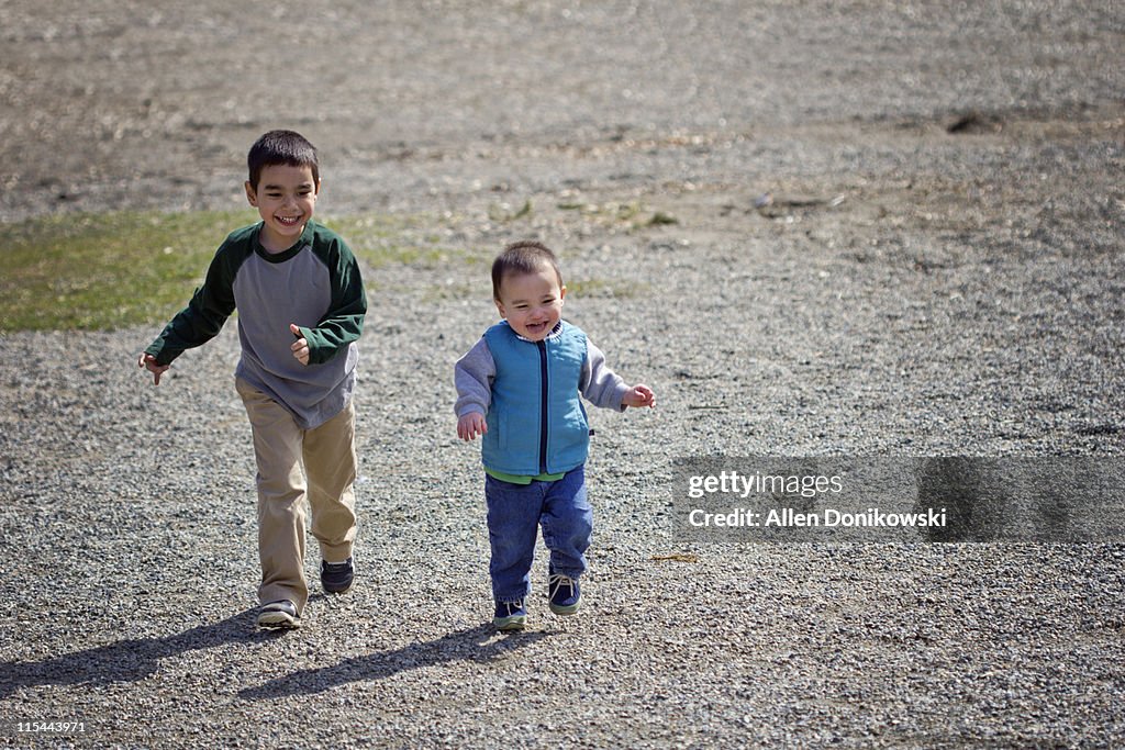 Brothers laughing and running together