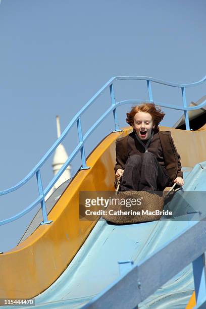 boy on fairground slide - catherine macbride stock pictures, royalty-free photos & images