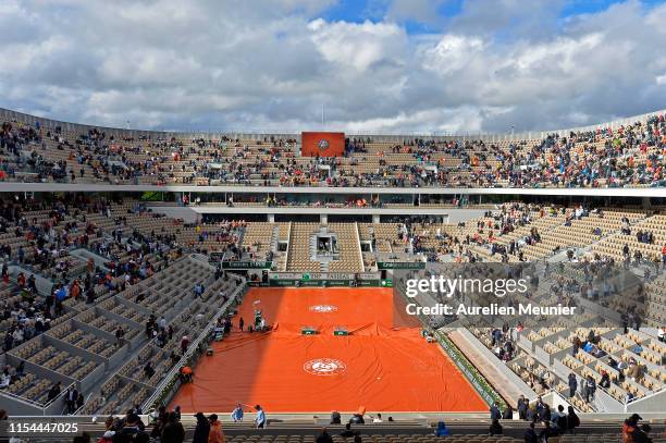 Covers are pulled over Court Philippe Chatrier due to a rain delay on Day thirteen of the 2019 French Open at Roland Garros on June 07, 2019 in...