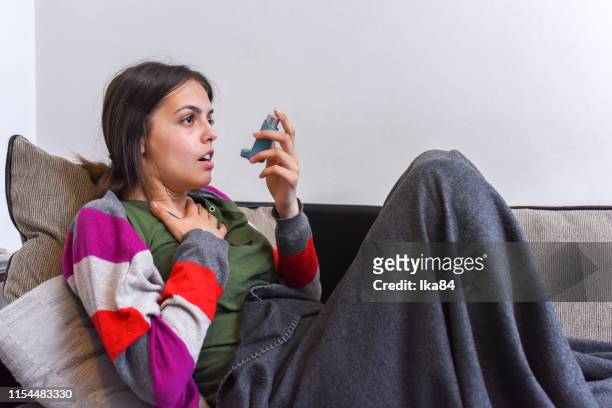 young woman using an asthma inhaler - nasal cannula stock pictures, royalty-free photos & images