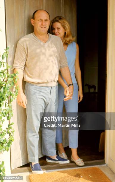 American television and film producer Bill Asher and wife American film, stage, and television actress Elizabeth Montgomery pose at the front door of...