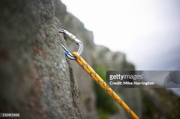 carabiner secured in rock surface - 爬山繩 個照片及圖片檔