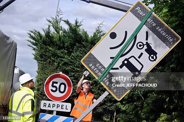 Des ouvriers de la société de services Spie démontent un panneau avertissant de la présence d'un radar, le 16 mai 2011 à Dijon, à la suite d'une des...