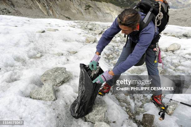 Des bénévoles ramassent des détritus le 1er octobre 2010 lors de l'opération de nettoyage de la Mer de Glace dans le Massif du Mont-Blanc, près de...