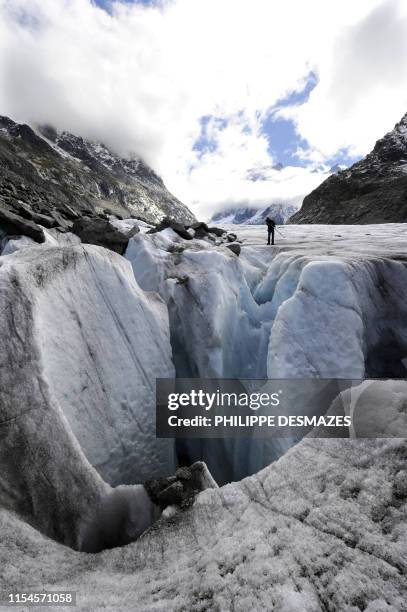 Des randonneurs évoluent aux bords d'une crevasse le 1er octobre 2010 de la Mer de glace dans le Massif du Mont-Blanc. AFP PHOTO / PHILIPPE DESMAZES...