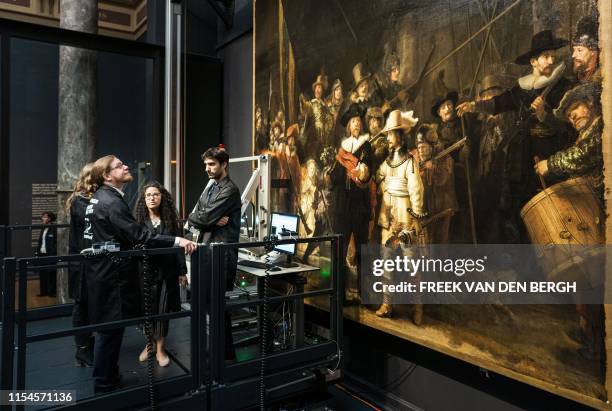 Restorers look at Rembrandt van Rijn's world-famous masterpiece "the Night Watch" in Amsterdam, on July 8, 2019. - Amsterdam's famed Rijksmuseum...